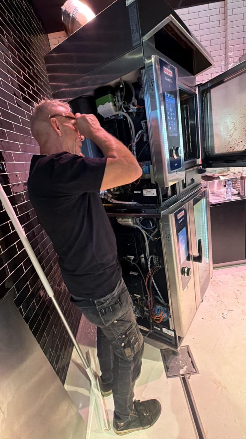 Monteur van Steamer Specialist werkt aan een RATIONAL iCombi combi-steamer